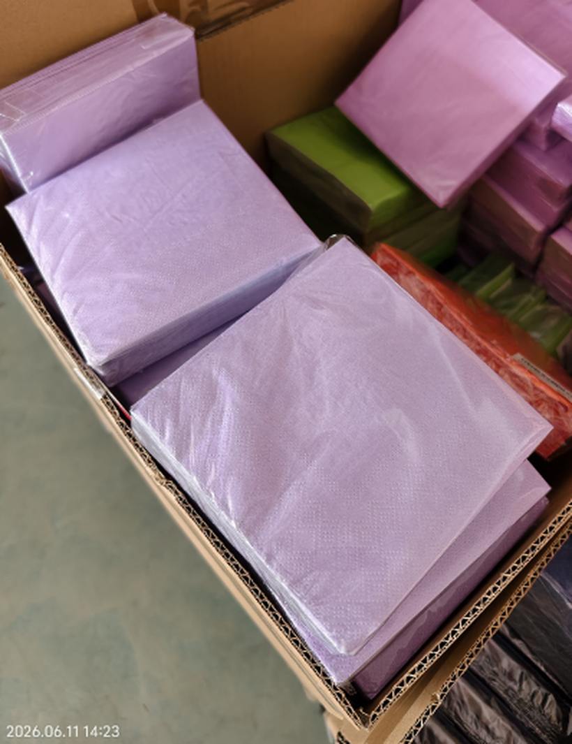Lavender napkin packs stacked in an open sample carton